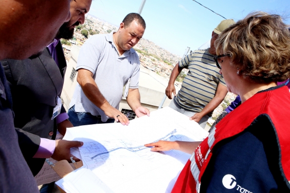 Vereador branco analisa um pepel branco, que contem mapa e projeto técnico de obra no bairro Vila do Sol