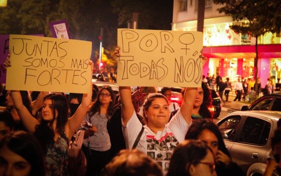 Mulheres em marcha, empunhando cartazes contra o fim da violência machista