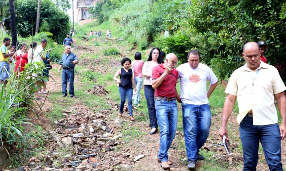 Vereador, convidados e moradores descem rua íngreme, em terra batida