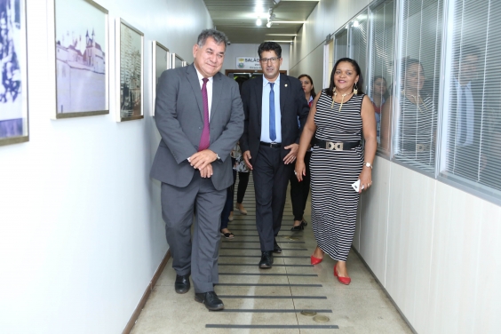 Vereador e vereadora de Petrolina, acompanhados por Jair Di Gregório, caminham por corredor da Câmara