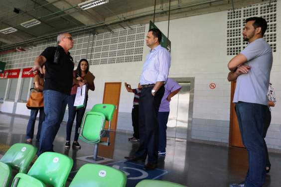 Comitiva em visita à Arena Independência. Sinalização no piso, atrás das cadeiras, indica área reservada para pessoas com deficiência