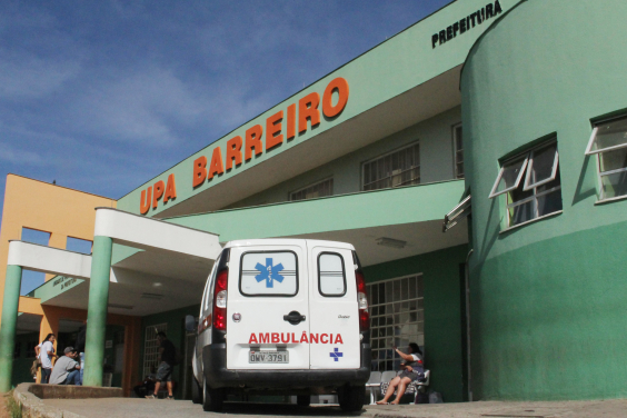 Fachada da UPA Barreiro. Prédio pintado de verde com letreiro vermelho indicativo ao alto. Na entrada, há uma ambulância estacionada.