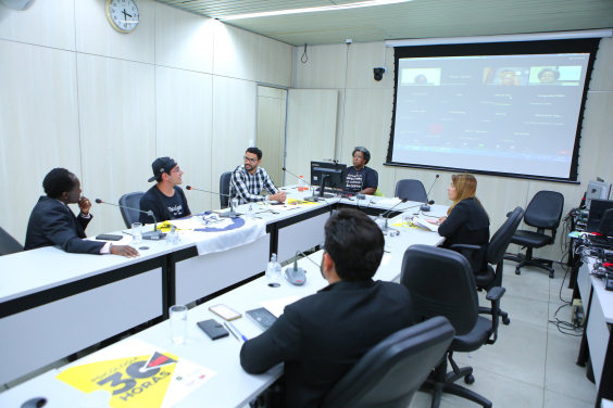 Imagem da sala durante a audiência com os participantes sentados em uma mesa em formato de U