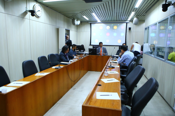 Dois parlamentares e dois homens reunidos, sentados à mesa