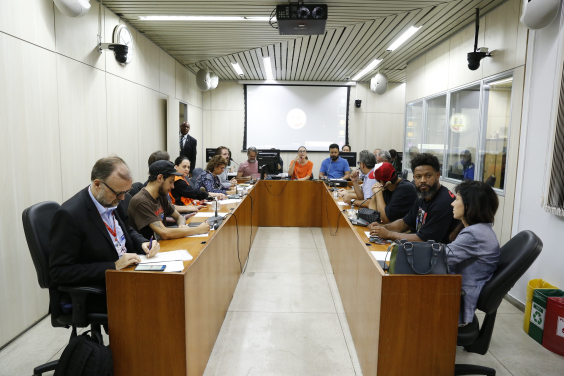 Vereadores se reunem com representantes do Executivo estadual e municipal e representantes da sociedade civil em uma mesa com cerca de 15 pessoas.