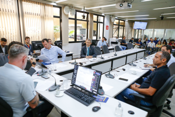 Imagem da reunião mostra uma sala cheia de participantes 