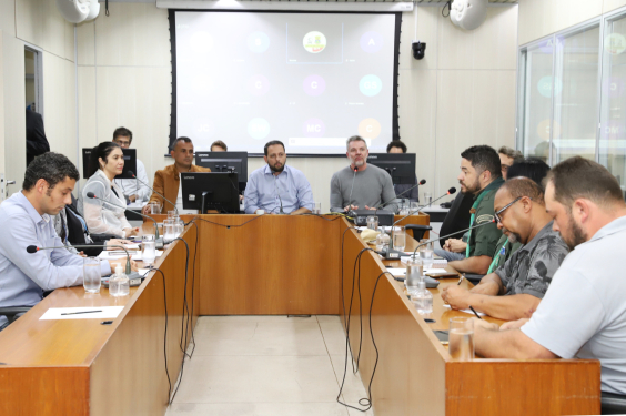 Quatro parlamentares e seis cidadãos e representantes do Município e de empresa, sentados à mesa, em reunião