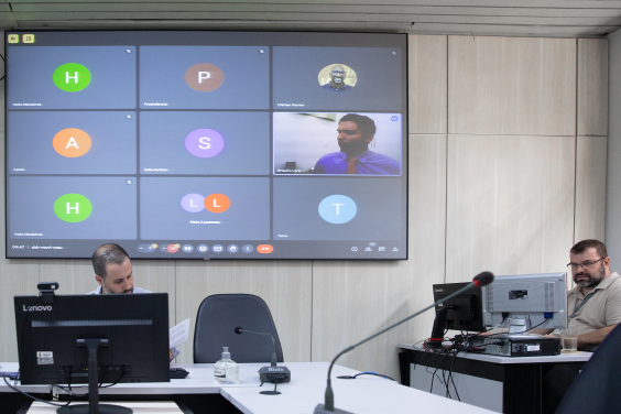 Imagem de vereador em telão que exibe reunião virtual de parlamentares.