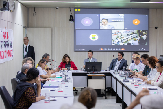 Imagem da mesa de reunião. Na cabeceira, os vereadores dr Célio Frois (PV)  e Jorge Santos (Republicanos ) e a deputada estadual Bela Gonçalves (Psol)