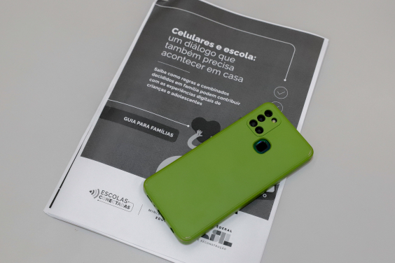 Celular em cima de livreto