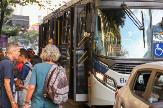 Pessoas entrando e saindo de ônibus