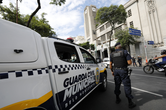 agente da guarda municipal ao lado de viatura