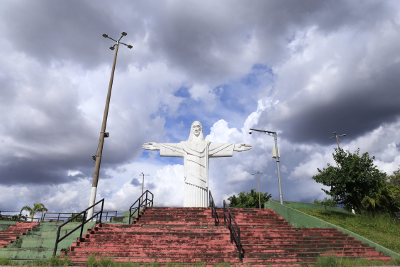 Imagem do Cristo do Barreiro no alto de uma escadaria. Ao fundo, o céu está nublado