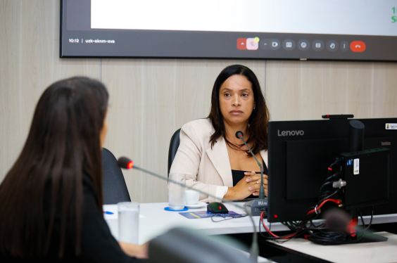 Mulher de costas observa a vereadora Loíde Gonçalves no Plenário Helvécio Arantes