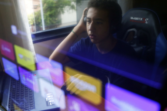 reflexo de um adolescente na tela de um computador
