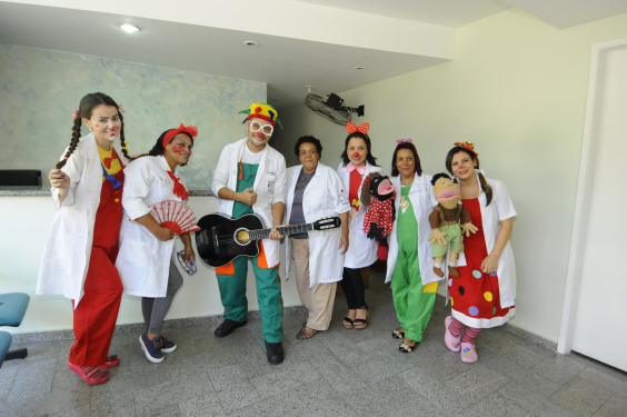 Profissionais vestindo jaleco branco e maquiagem de palhaço