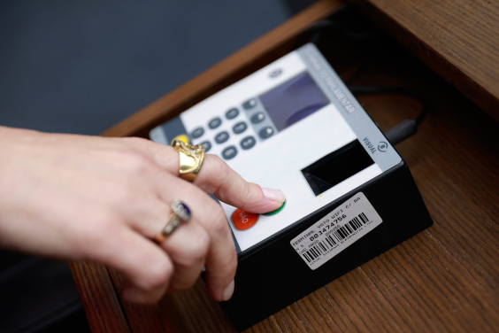 Mão pressiona equipamento eletrônico de votação na Câmara Municipal