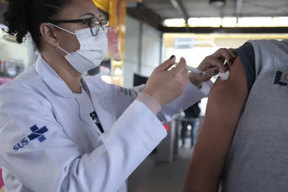 profissional de saúde faz aplicação de vacina