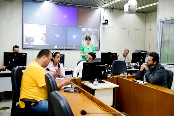 Parlamentares reunidos em volta de mesa durante reunião da Comissão que aprovou parecer favorável ao projeto