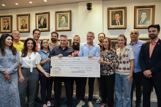 Vereadores e prefeito de BH seguram cheque representativo com o valor repassado