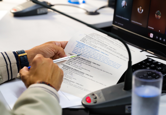 mãos masculinas manuseiam documento segurando uma caneta
