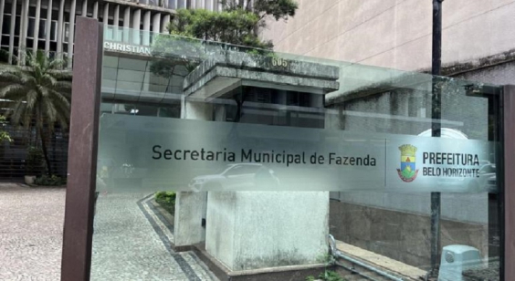 Placa de vidro onde está escrito "Secretaria Municipal de Fazenda" com a logo da Prefeitura de Belo Horizonte ao lado