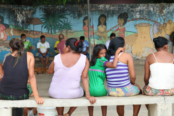 grupo de mulheres sentadas em banco, vistas de costas