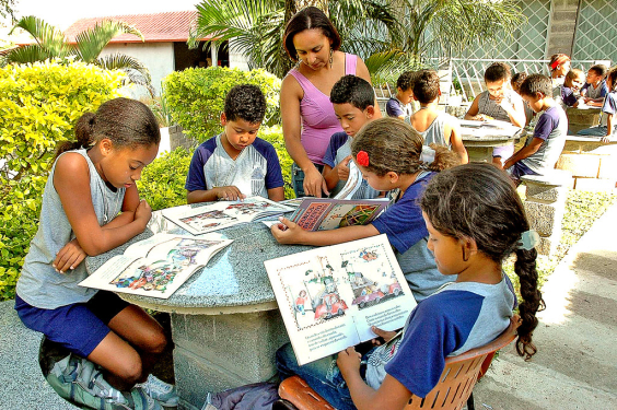 grupo de crianças leem sentados em mesa