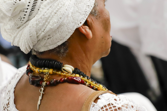 Mulher de costas com vestimentas de terreiro