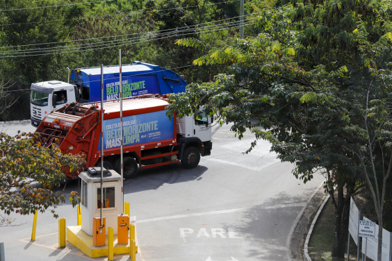 caminhões de coleta de lixo trafegando em via pública