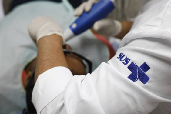 Médico com jaleco do SUS faz atendimento