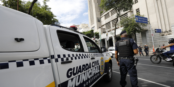 agente da guarda municipal ao lado de viatura