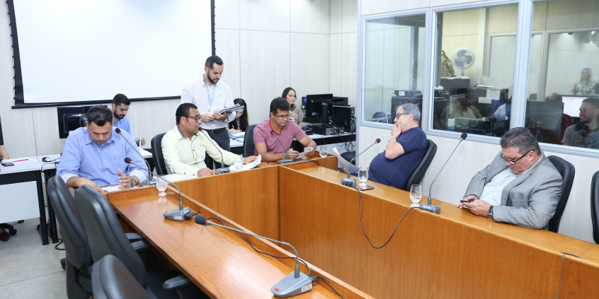 Os cinco membros titulares da comissão estão sentados à Mesa, apreciando a pauta da reunião que i