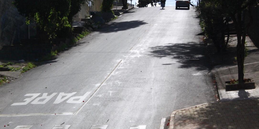 Imagem de rua asfaltada com declividade acentuada