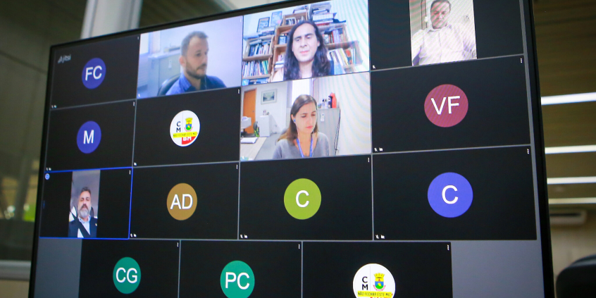 Duas mulheres e três homens dividem tela de computador em reunião remota virtual.