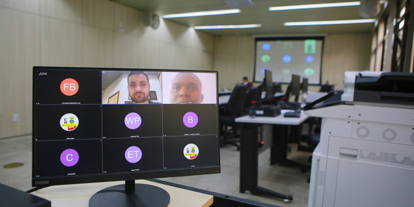 Dois homens dividem tela de computador em reunião remota.