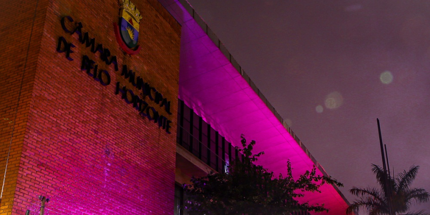 Fachada da câmara iluminada de lilás, à noite. 
