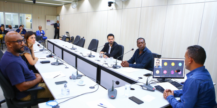 Cinco parlamentares em reunião, sentados à mesa.