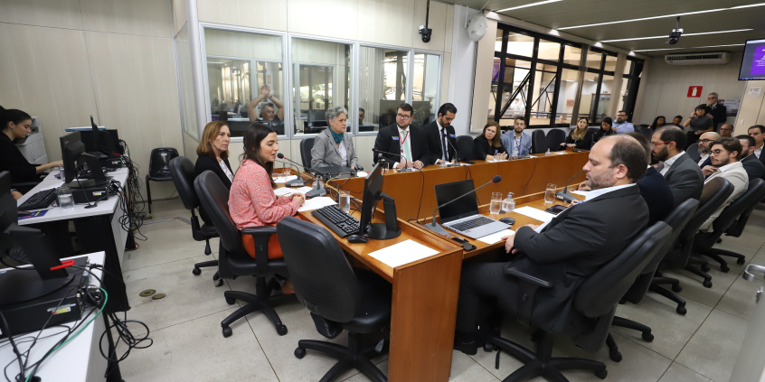 Imagem da sala de reunião identificando os vereadores e especialistas que compõe a mesa e o público que acompanha a audiência