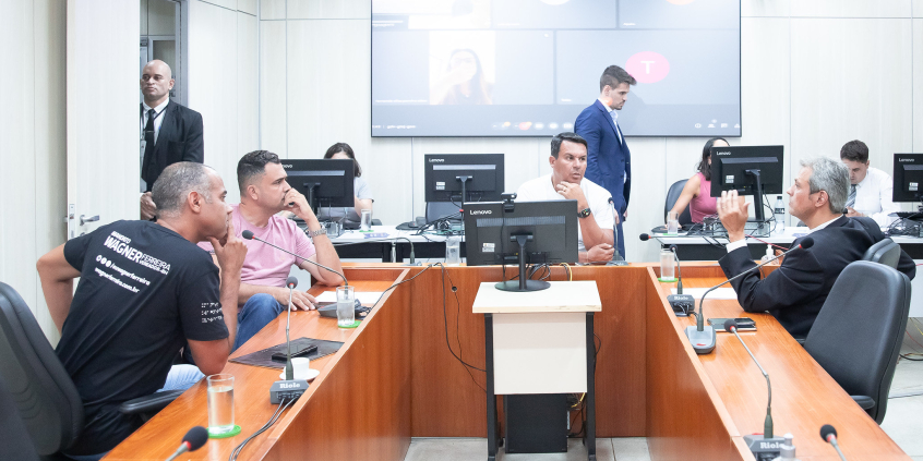 Imagem dos parlamentares em torno da mesa de reunião no Plenário Camil Caran.