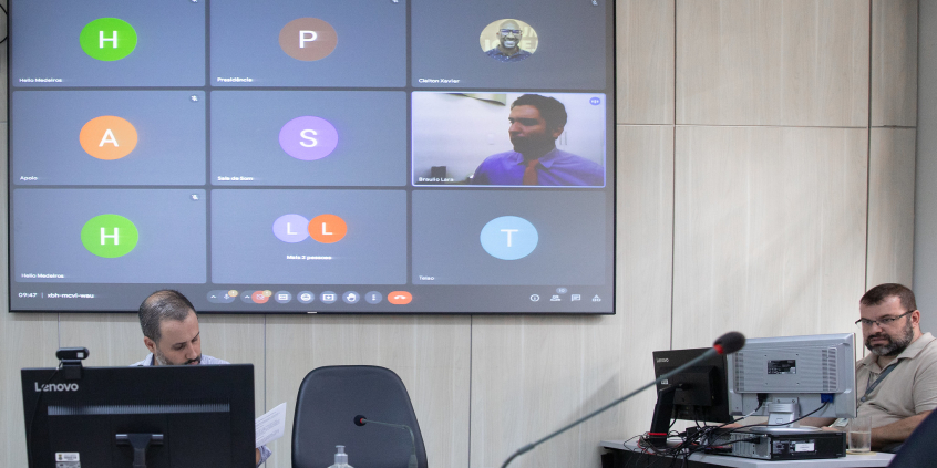 Imagem de vereador em telão que exibe reunião virtual de parlamentares.