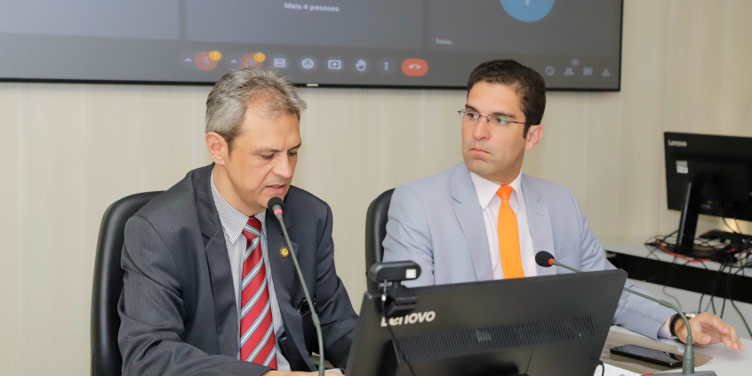 Dois vereadores reunidos, sentados à mesa
