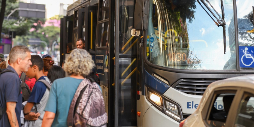 imagem da frente de um ônibus com pessoas entrando e em pé na porta
