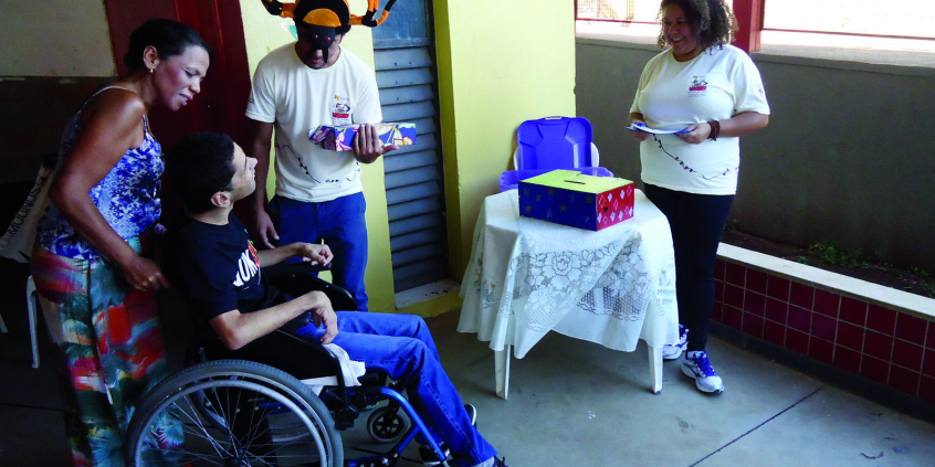 Pessoa em cadeira de rodas conversa com outras pessoas