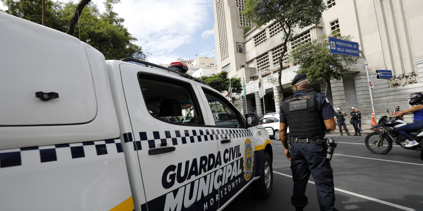 agente da guarda municipal ao lado de viatura