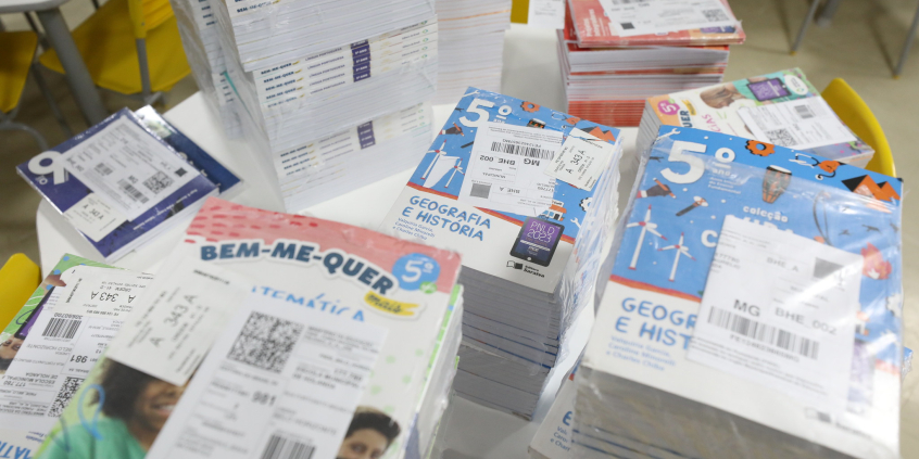 livros didáticos infantis empilhados e dispostos sobre uma mesa