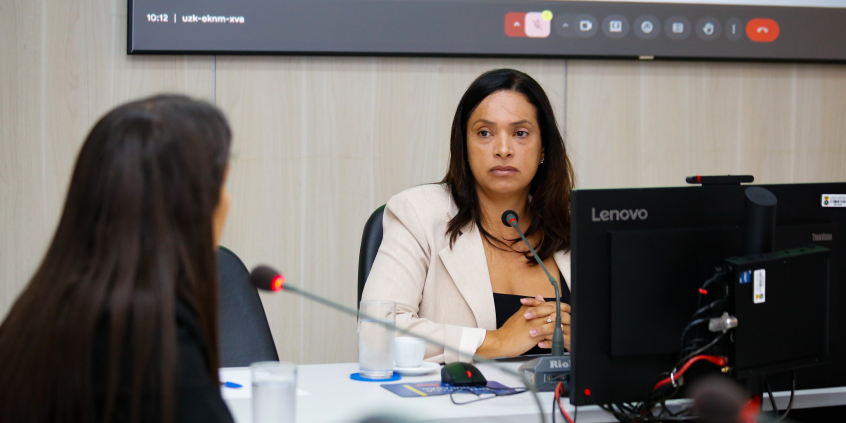Mulher de costas observa a vereadora Loíde Gonçalves no Plenário Helvécio Arantes