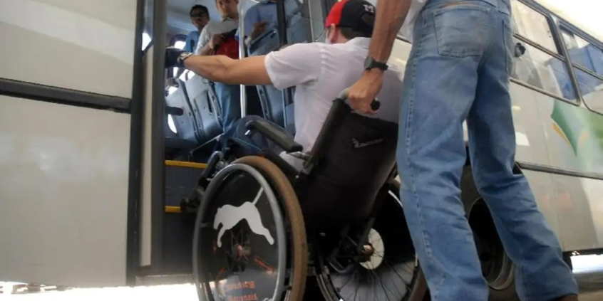 homem cadeirante é auxiliado a entrar em ônibus