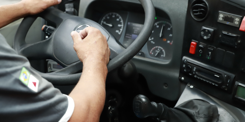 close nas mãos de motorista segurando voltante de automóvel