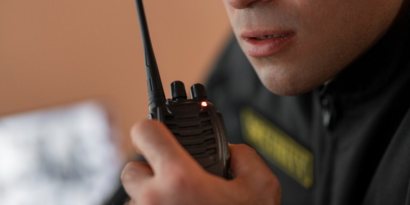 Homem segurando rádio usado por vigilantes